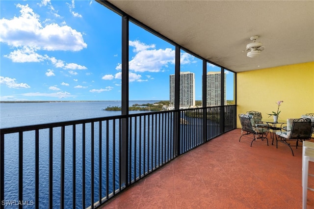 sunroom / solarium featuring a water view