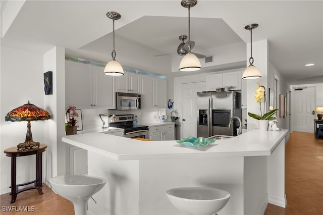 kitchen with a peninsula, a sink, visible vents, light countertops, and appliances with stainless steel finishes