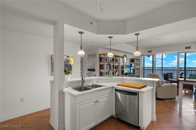 kitchen with a sink, open floor plan, light countertops, dishwasher, and decorative light fixtures