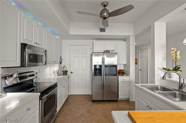 kitchen with a sink, visible vents, white cabinetry, light countertops, and appliances with stainless steel finishes