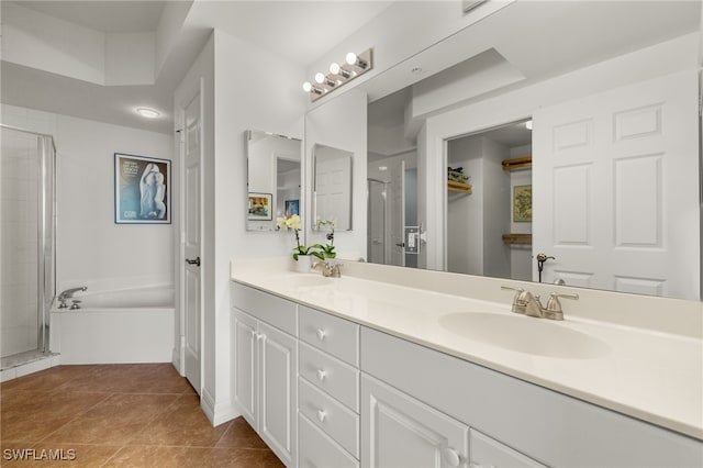 full bathroom featuring double vanity, a stall shower, a sink, and tile patterned floors