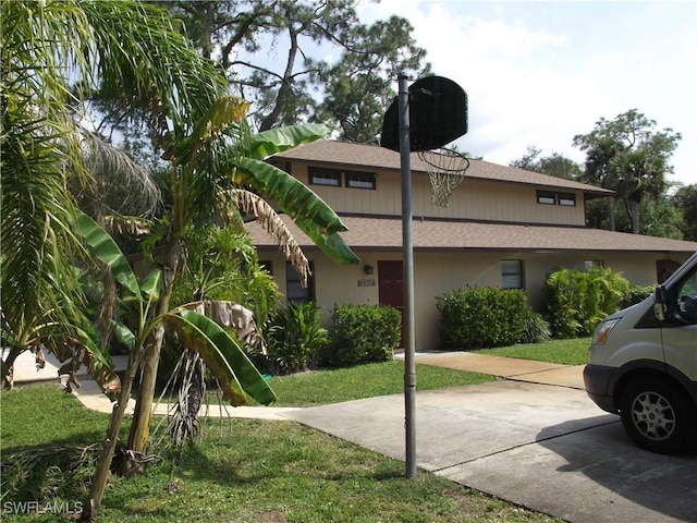 view of side of home with stucco siding and roof with shingles