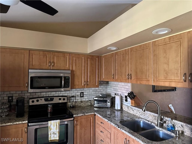 11570 Caravel Cir Unit 2022, Fort Myers, FL 33908 - kitchen with stainless steel appliances, a sink, brown cabinetry, and tasteful backsplash