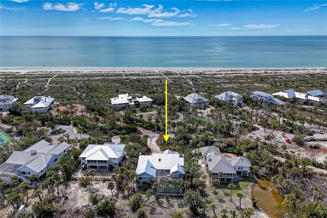 birds eye view of property featuring a beach view and a water view