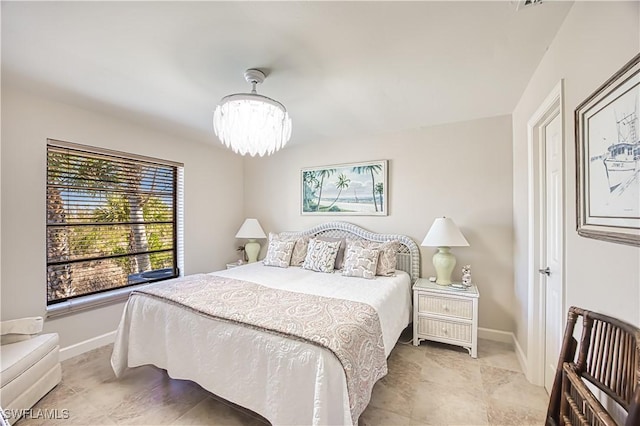 bedroom featuring a chandelier and baseboards