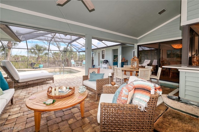 sunroom featuring a ceiling fan, lofted ceiling, and visible vents