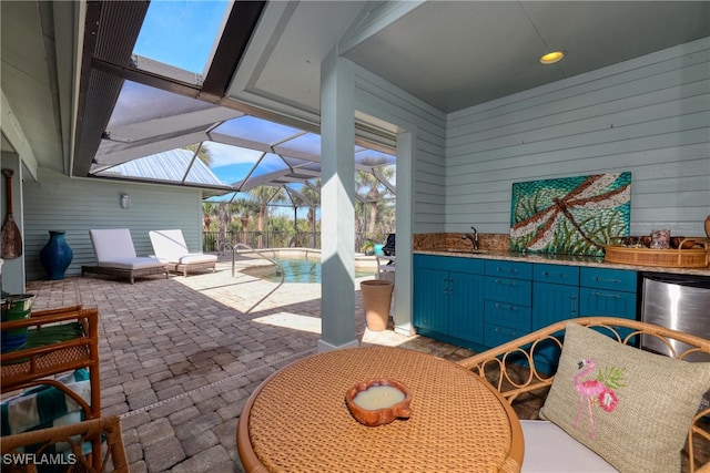 view of patio with a sink, a lanai, and an outdoor pool