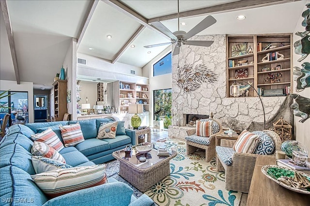 living room with visible vents, a stone fireplace, beamed ceiling, and a ceiling fan