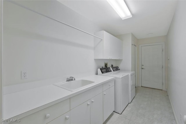 clothes washing area featuring baseboards, washer and clothes dryer, light tile patterned floors, cabinet space, and a sink