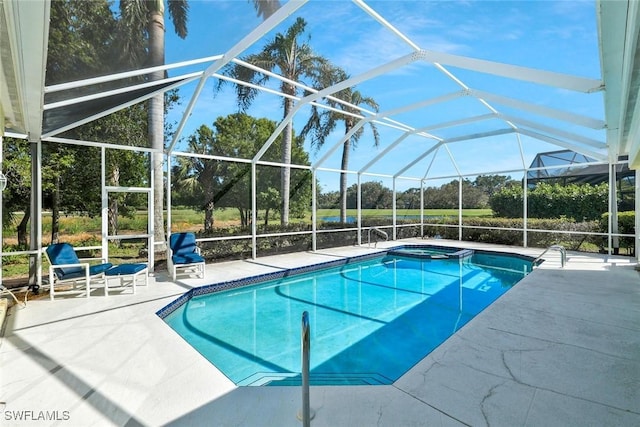 view of pool with glass enclosure and a patio