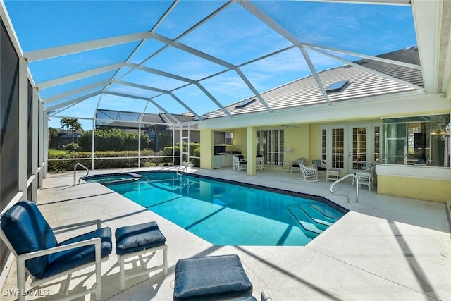 view of swimming pool with french doors, a pool with connected hot tub, a lanai, and a patio area