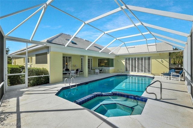 view of swimming pool with glass enclosure, a patio area, and a pool with connected hot tub