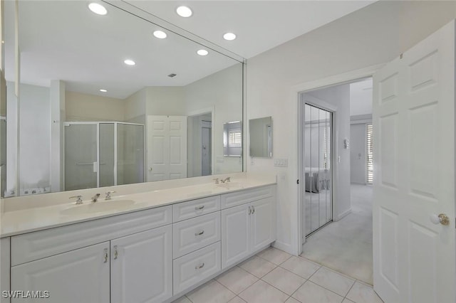 full bath featuring tile patterned floors, a stall shower, a sink, recessed lighting, and double vanity