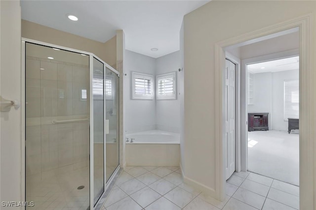 bathroom featuring tile patterned floors, baseboards, a stall shower, and a bath