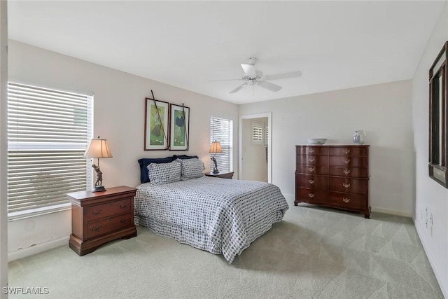 bedroom with light colored carpet, baseboards, and ceiling fan