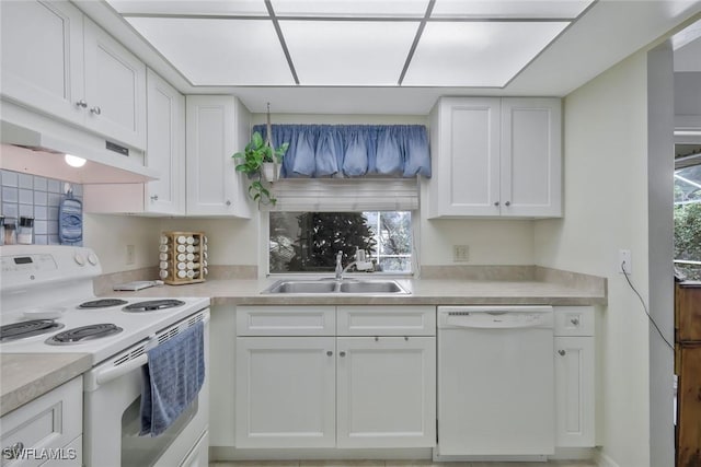 kitchen featuring white appliances, white cabinets, a sink, and light countertops