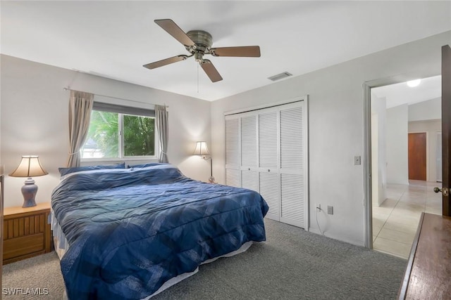 bedroom featuring light carpet, a closet, visible vents, and a ceiling fan