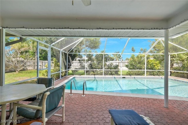 view of pool featuring glass enclosure, a patio, a fenced backyard, and a fenced in pool