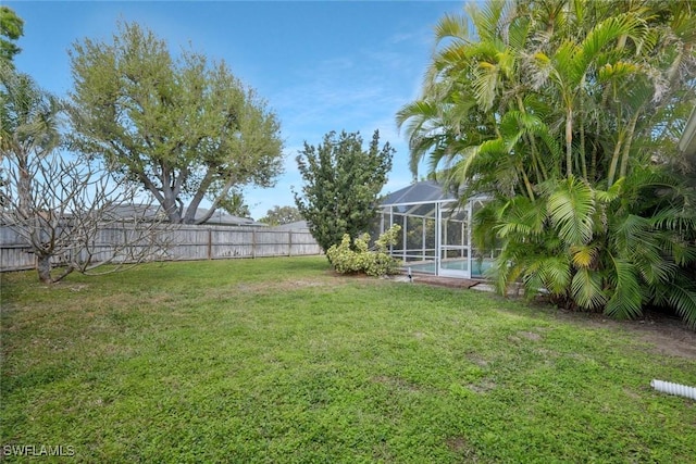 view of yard featuring a fenced in pool, glass enclosure, and a fenced backyard