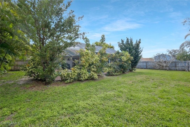 view of yard featuring a lanai and a fenced backyard