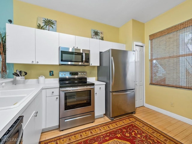 kitchen with white cabinetry, appliances with stainless steel finishes, and a sink