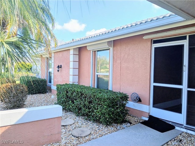 view of home's exterior with a tiled roof and stucco siding