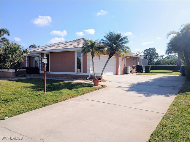 view of front of property featuring driveway, central AC unit, an attached garage, a front yard, and stucco siding