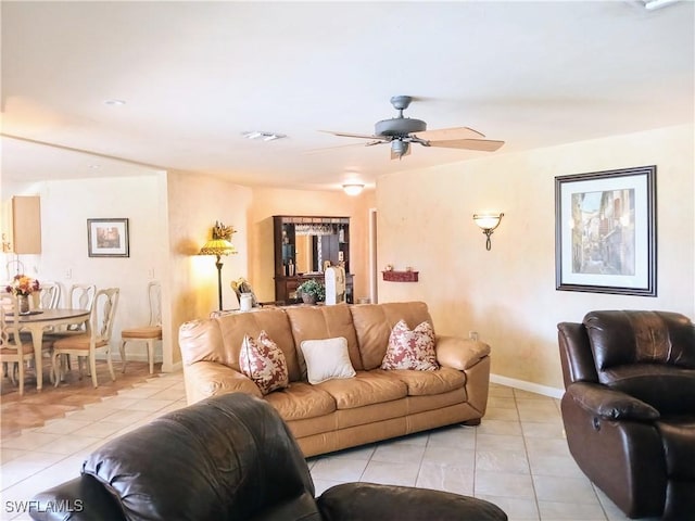 living area with light tile patterned floors, visible vents, baseboards, and ceiling fan