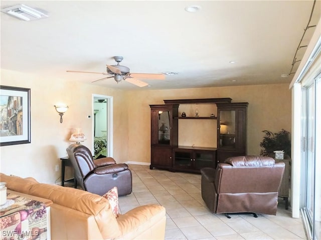 living room featuring a ceiling fan, visible vents, and light tile patterned floors