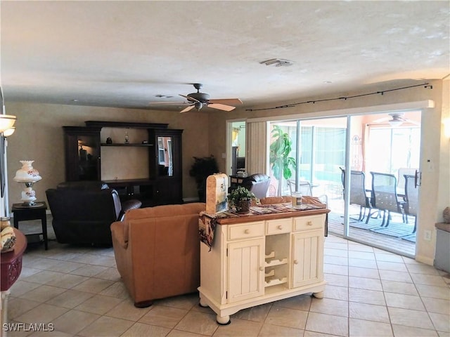 living area featuring light tile patterned floors and ceiling fan