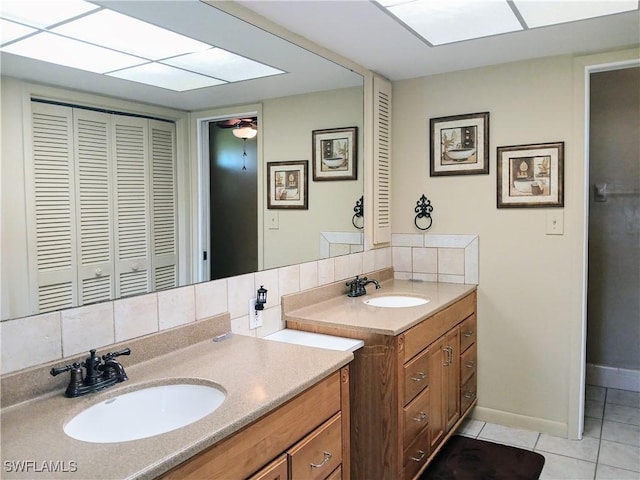 full bathroom with tile patterned flooring, decorative backsplash, two vanities, and a sink