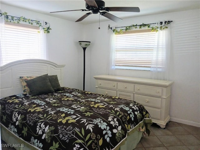 bedroom with ceiling fan, multiple windows, tile patterned flooring, and baseboards