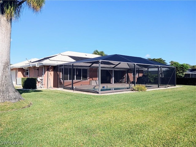 rear view of property with glass enclosure, a lawn, a patio area, and an outdoor pool