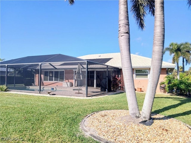 rear view of house with a patio area, glass enclosure, an outdoor pool, and a yard