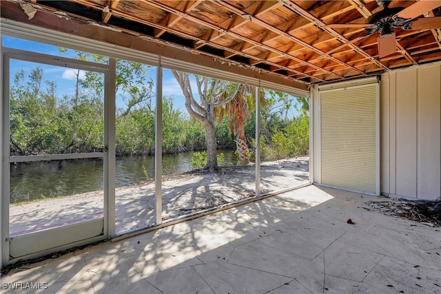 unfurnished sunroom featuring a water view