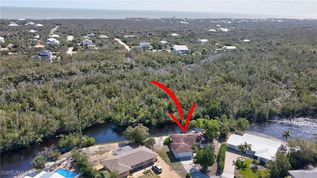 drone / aerial view with a water view and a view of trees