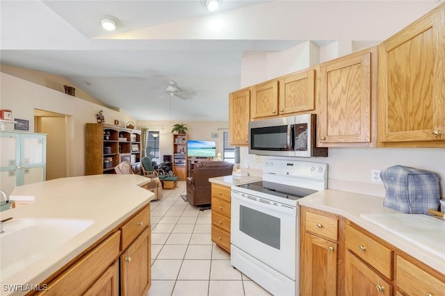 kitchen featuring stainless steel microwave, vaulted ceiling, light tile patterned flooring, white electric range, and a sink