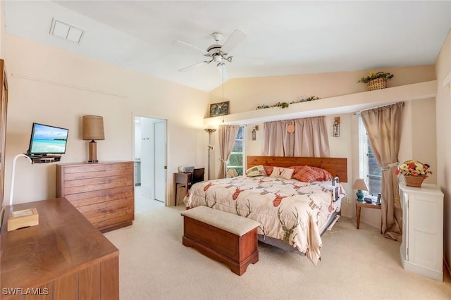 bedroom featuring multiple windows, lofted ceiling, light colored carpet, and visible vents