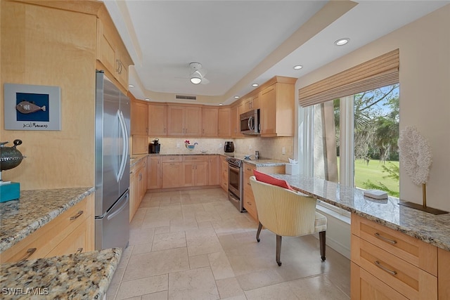 kitchen featuring visible vents, decorative backsplash, appliances with stainless steel finishes, light stone countertops, and light brown cabinets