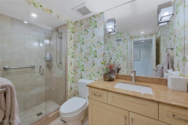 full bath featuring toilet, vanity, visible vents, a shower stall, and wallpapered walls