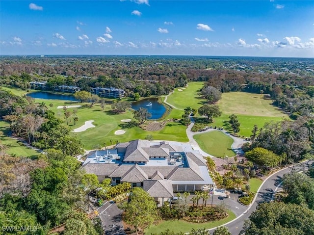 birds eye view of property with view of golf course, a water view, and a wooded view