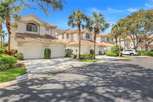 mediterranean / spanish-style house featuring a garage, a tile roof, driveway, and stucco siding