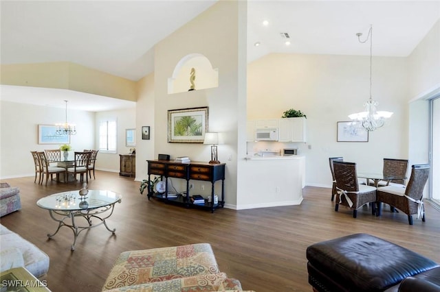 living area featuring high vaulted ceiling, a notable chandelier, dark wood-style flooring, visible vents, and baseboards