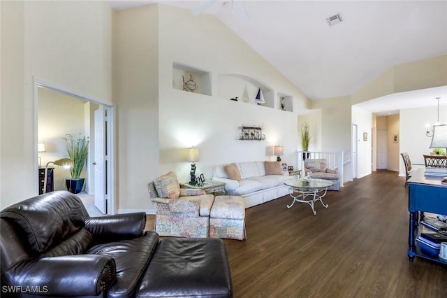 living area featuring high vaulted ceiling, visible vents, and wood finished floors