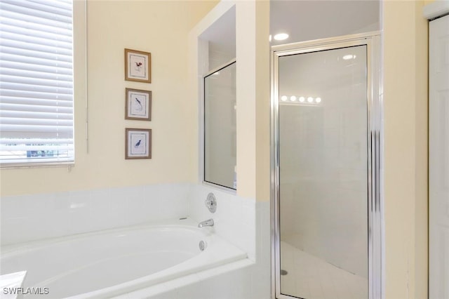 full bath featuring a stall shower and a garden tub