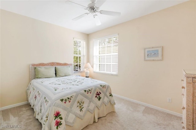 bedroom with light carpet, baseboards, and a ceiling fan