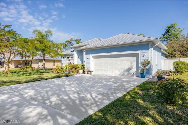 single story home featuring metal roof, an attached garage, fence, driveway, and a front yard