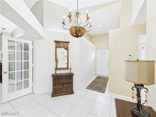 tiled entryway featuring a high ceiling, an inviting chandelier, visible vents, and baseboards