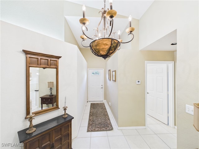 foyer featuring high vaulted ceiling, light tile patterned flooring, a notable chandelier, and baseboards