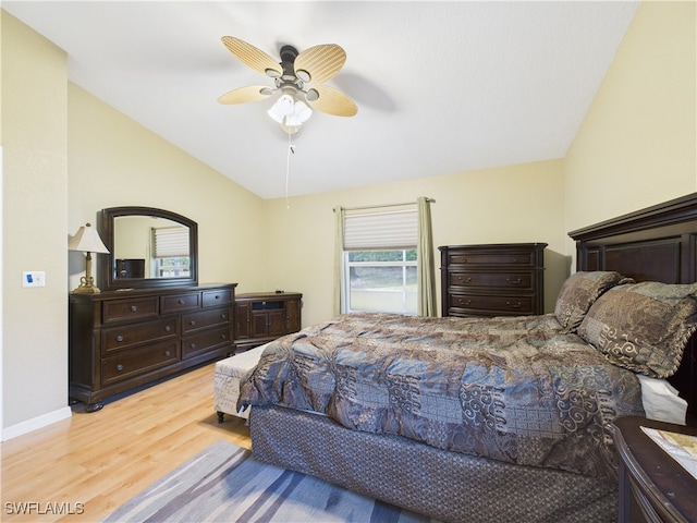 bedroom with vaulted ceiling, baseboards, light wood-style flooring, and a ceiling fan